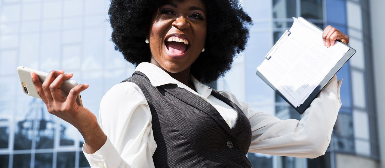 Glad kvinna utanför kontorsbyggnad